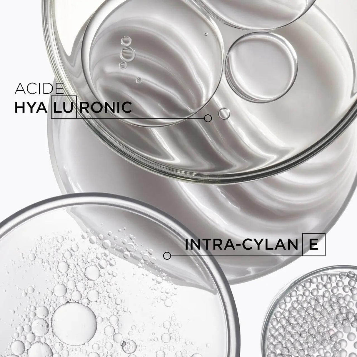 Close-up of hair care ingredients: hyaluronic acid and intra-cylane displayed in clear round containers for hair treatment.