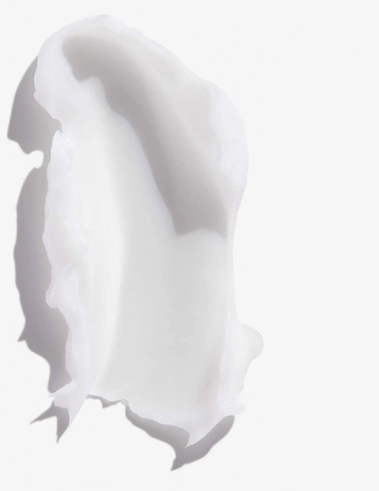 Scoop of Redken Frizz Dismiss Conditioner showcasing creamy texture designed to reduce frizz and smooth all hair types.