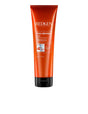 Redken Frizz Dismiss Mask for frizz-free, smooth hair conditioning in orange tube.