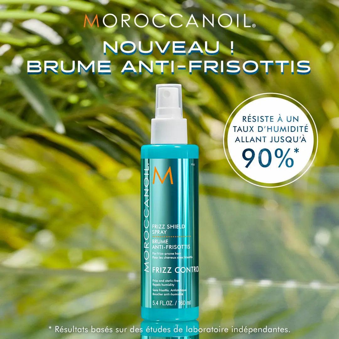 Moroccanoil Frizz Shield Spray bottle with 90% humidity resistance claim, set against a lush green background.