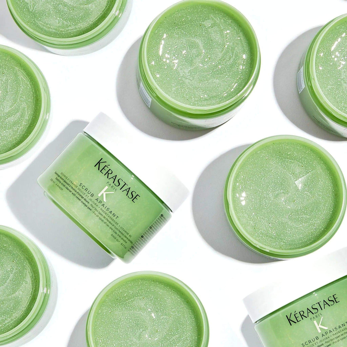 Kérastase Fusio Scrub Apaisant jars displayed, green scalp scrub for cleansing and calming all hair types, tackling buildup and oiliness.