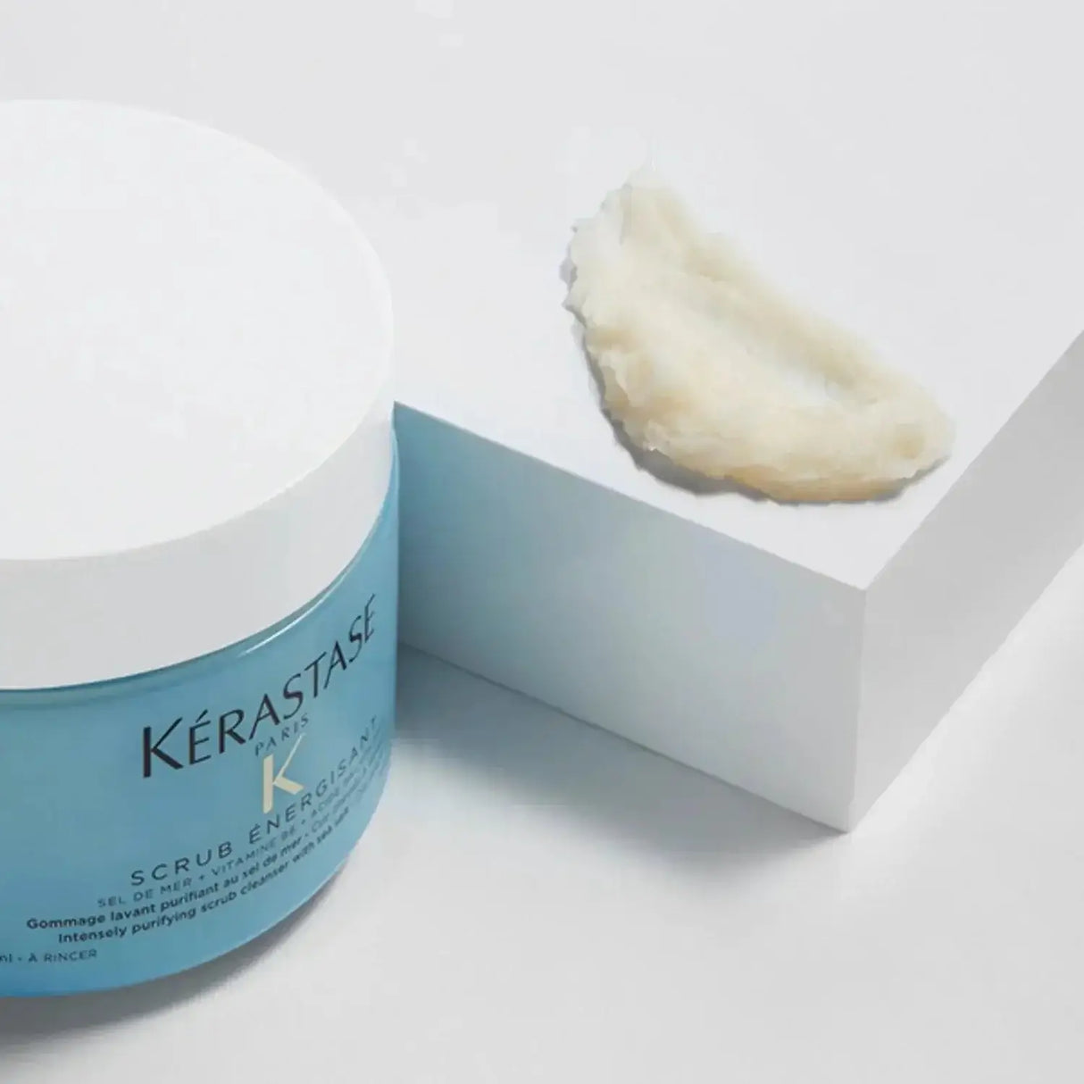Kerastase Fusio Scrub Energisant jar with exfoliating scalp treatment smear on white background.