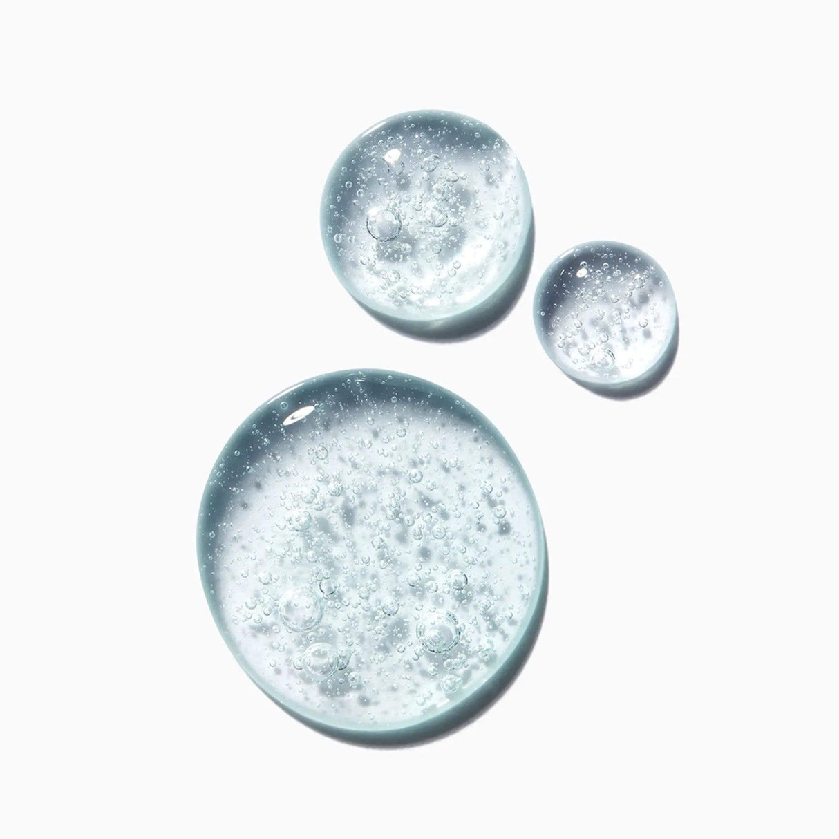 Close-up of Kérastase Genesis Homme Bain De Masse Épaississant Shampoo texture, showcasing clear bubbly consistency.
