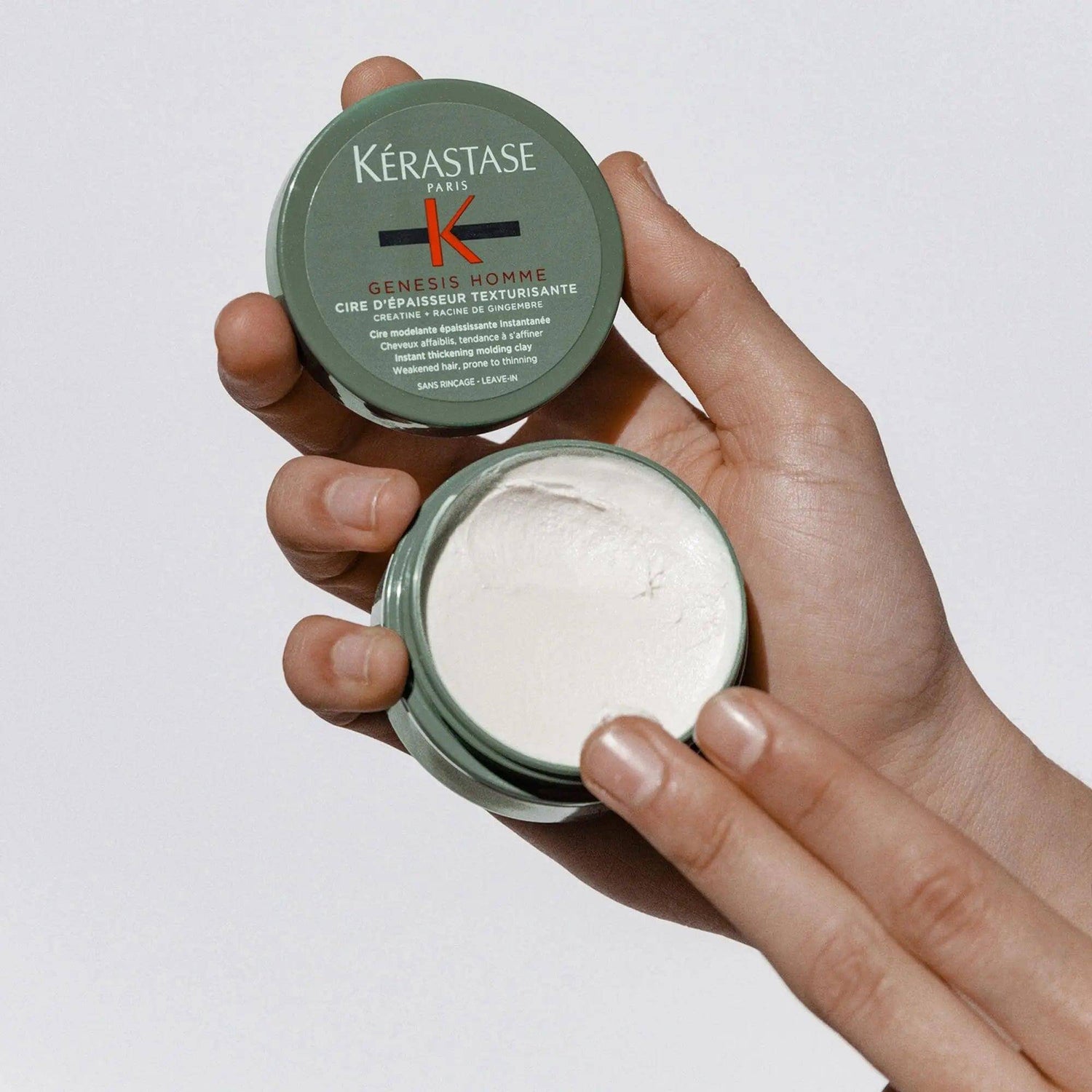 Kérastase Genesis Homme Cire d'Épaisseur Texturisante hair wax in a person's hands.