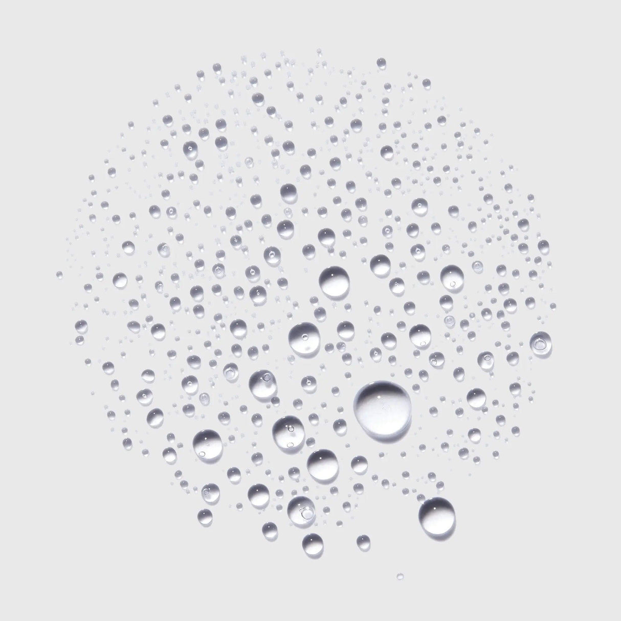 Close-up of water droplets forming a circular pattern against a light background, symbolizing freshness and hydration.