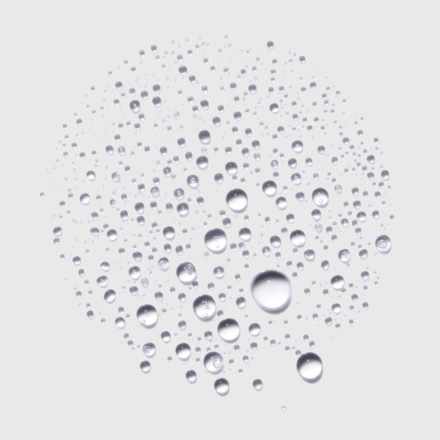 Close-up of water droplets forming a circular pattern against a light background, symbolizing freshness and hydration.