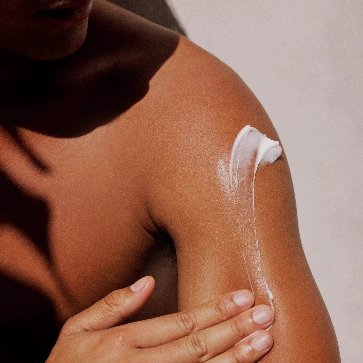 Person applying Gilded Woods Body Lotion for smooth, hydrated skin with a non-greasy formula containing Shea Butter and Aloe Vera.