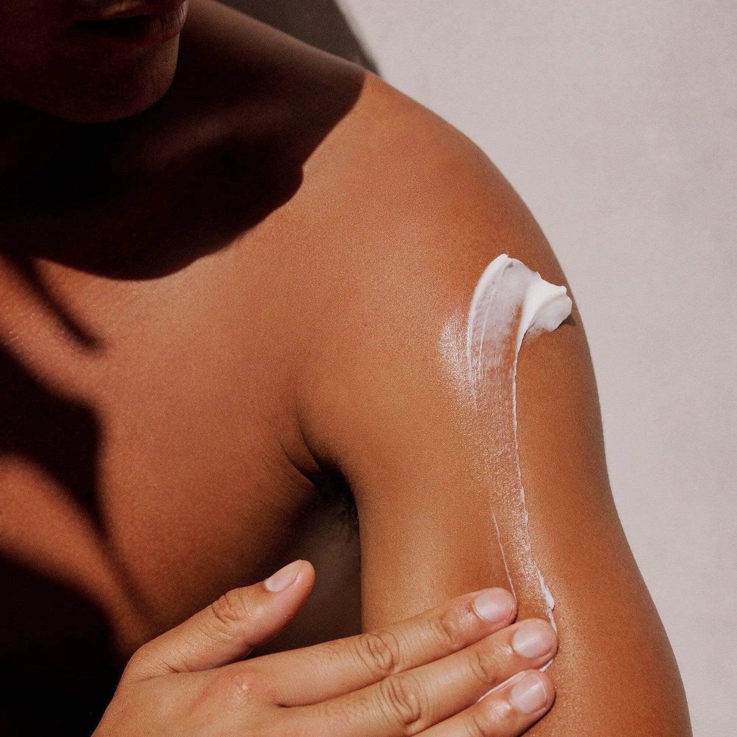 Person applying Gilded Woods Body Lotion for smooth, hydrated skin with a non-greasy formula containing Shea Butter and Aloe Vera.