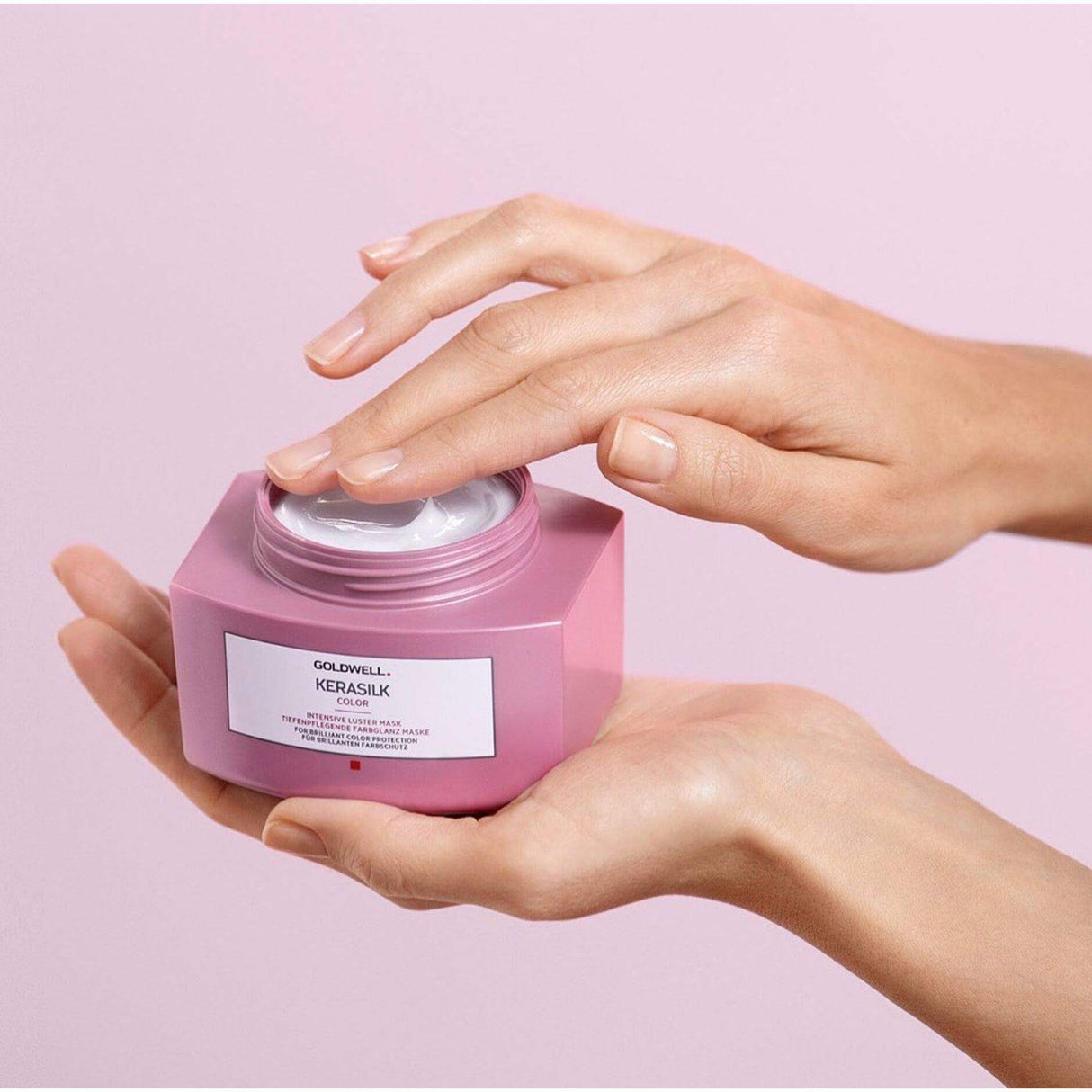 Hands holding Goldwell Kerasilk Color Intensive Luster Mask for damaged hair repair and smoothness.