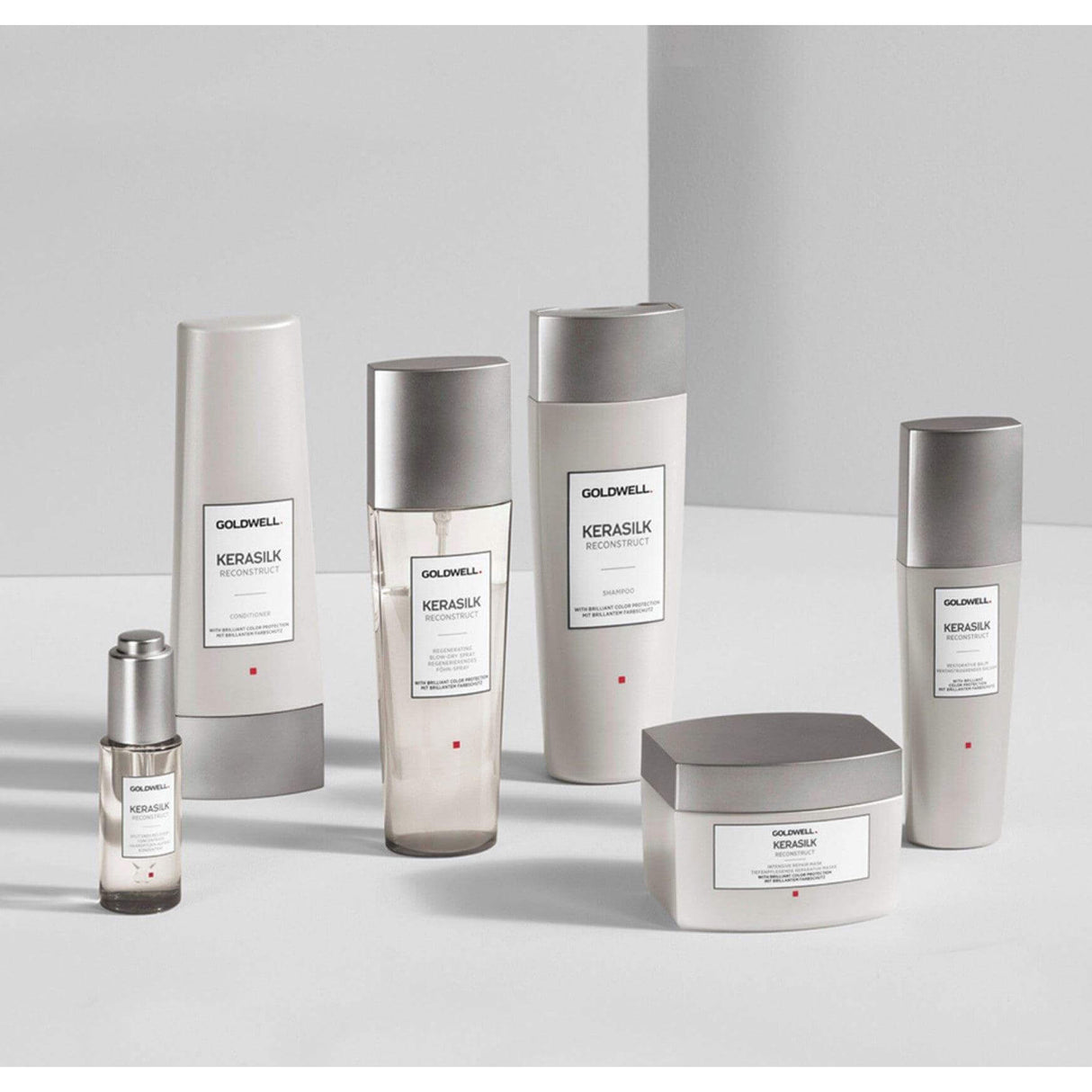 Goldwell Kerasilk hair care products, including the Reconstruct Intensive Repair Mask, arranged on a minimalist white background.