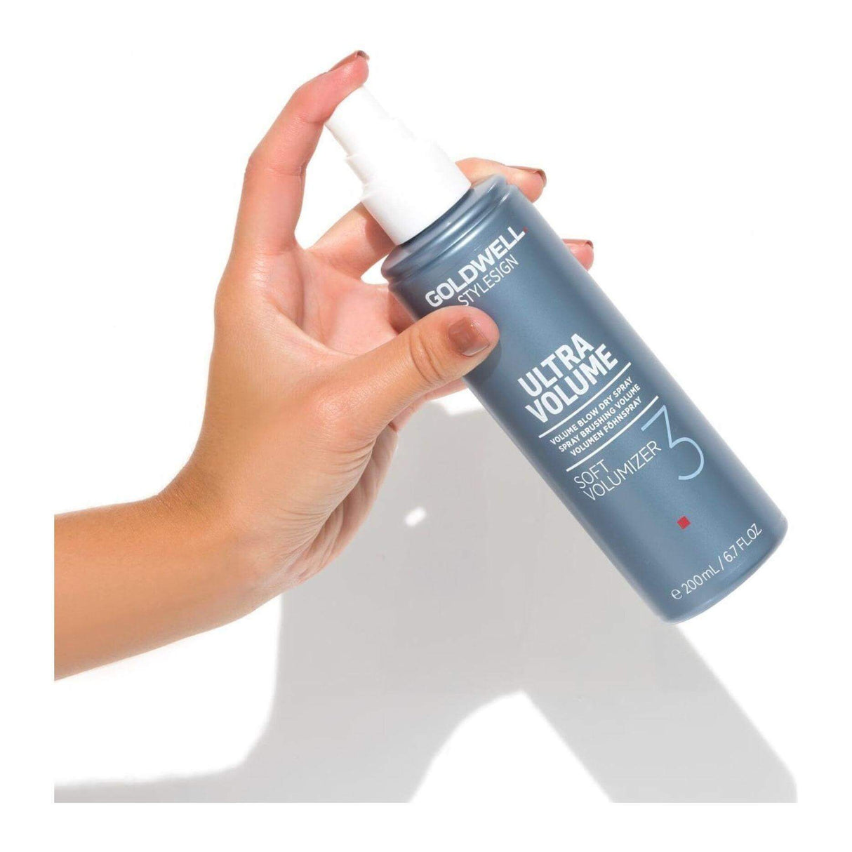 Person holding Goldwell Stylesign Ultra Volume Soft Volumizer Blow Dry Spray for flexible, natural hair volume.