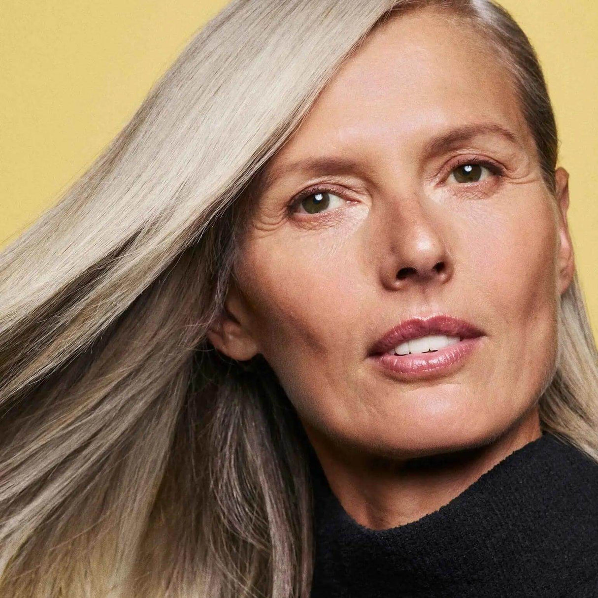 Person with smooth, shiny hair demonstrating the effects of Hair Alchemy Resilience Conditioner.