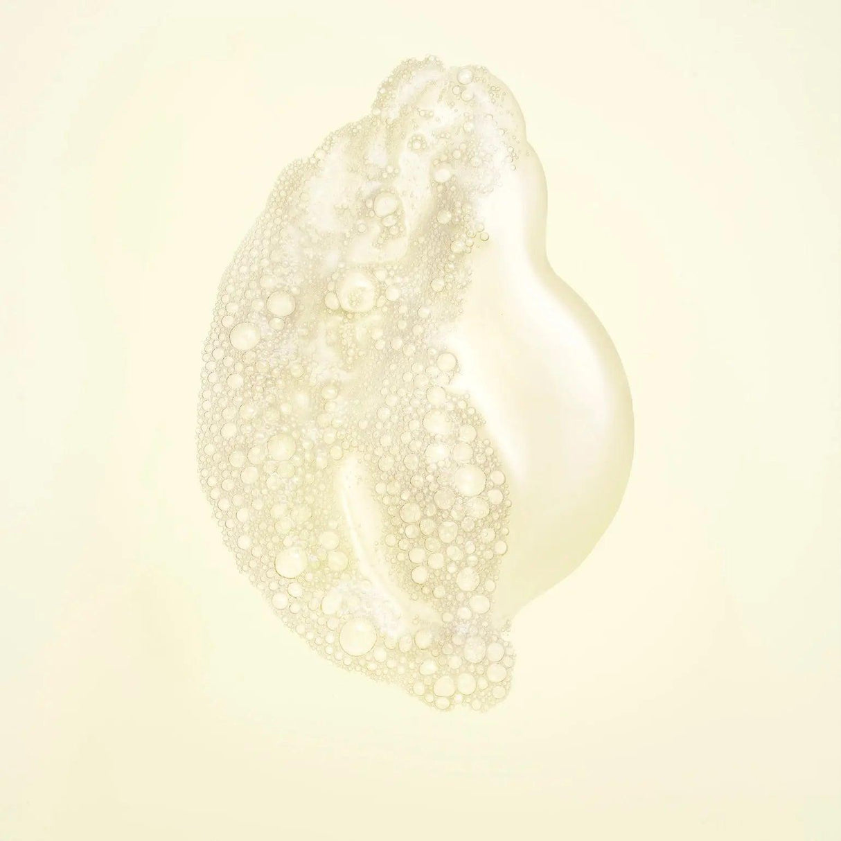 Close-up of Hair Alchemy Resilience Shampoo with chia seed and bamboo leaf extracts, highlighting nourishing bubbles.