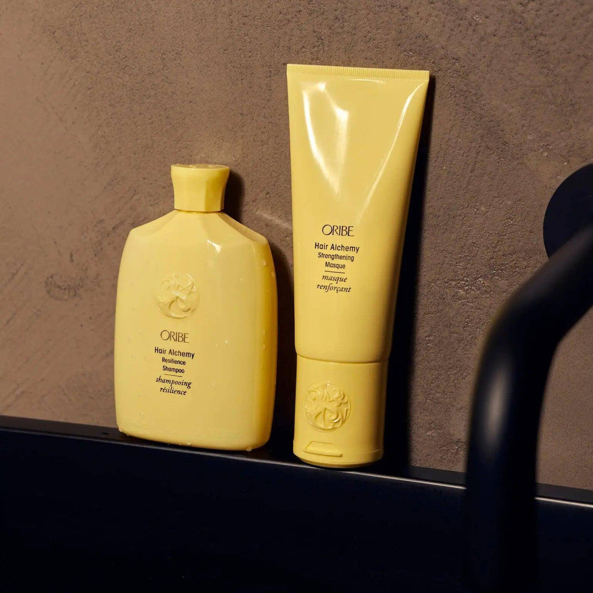 Hair Alchemy Strengthening Masque and Shampoo bottles on bathroom counter.
