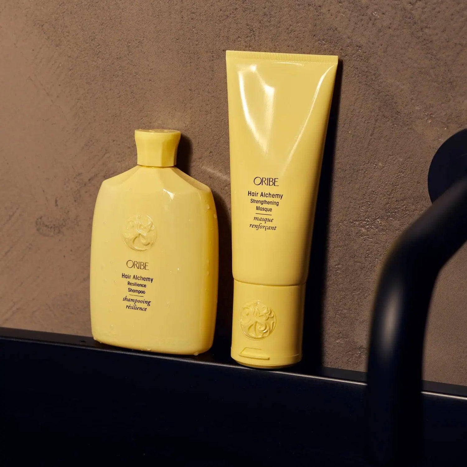 Hair Alchemy Strengthening Masque and Shampoo bottles on bathroom counter.