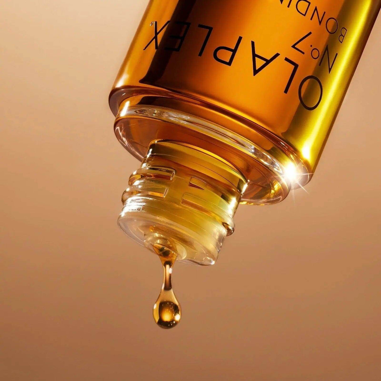 Olaplex No.7 Bonding Oil dripping from bottle, highlighting premium hair protection and styling benefits.