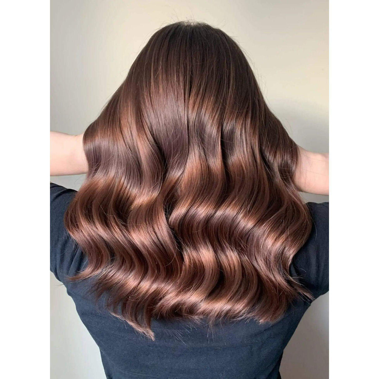 Woman with smooth, shiny, frizz-free styled hair showcasing Iconic Styling Duo's effect, including No.6 Bond Smoother and No.7 Styling Oil.