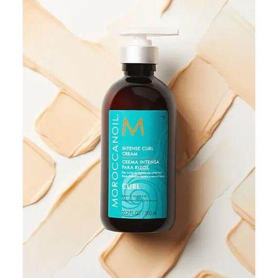 Moroccanoil Intense Curl Cream bottle with argan oil for shiny and soft natural curls, 10.2 fl oz, on textured background.