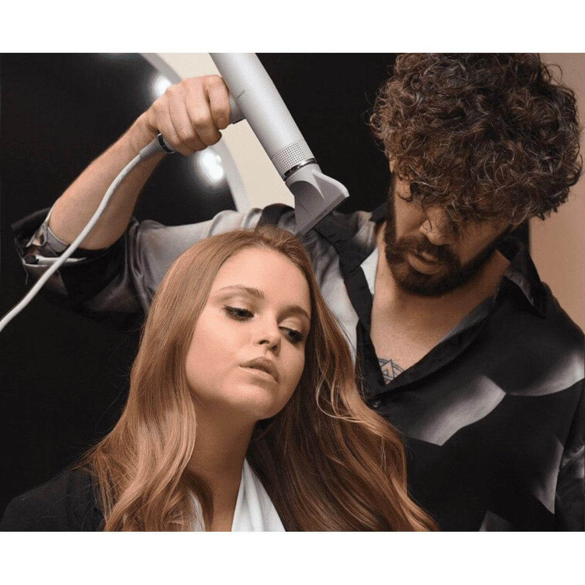 Professional stylist using IQ Perfetto Hair Dryer on woman’s hair, showcasing lightweight design and advanced technology for salon results.