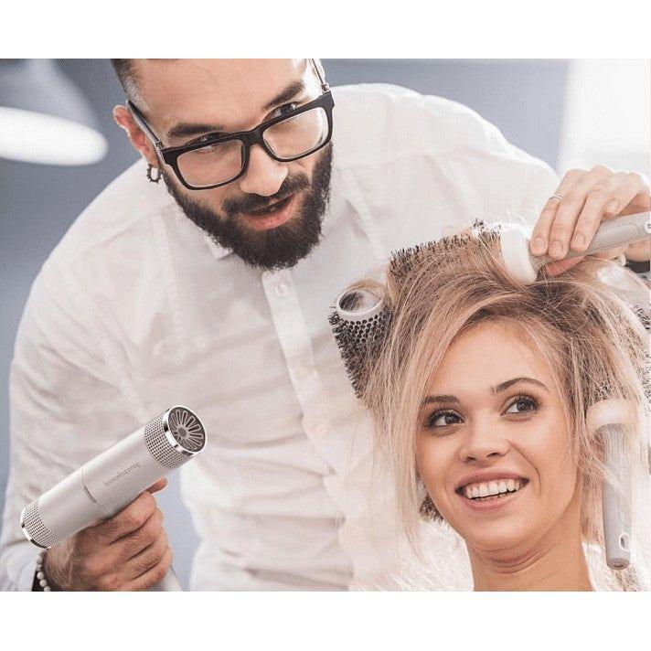 Professional stylist using IQ Perfetto Hair Dryer on client's hair, demonstrating lightweight and ergonomic design features.
