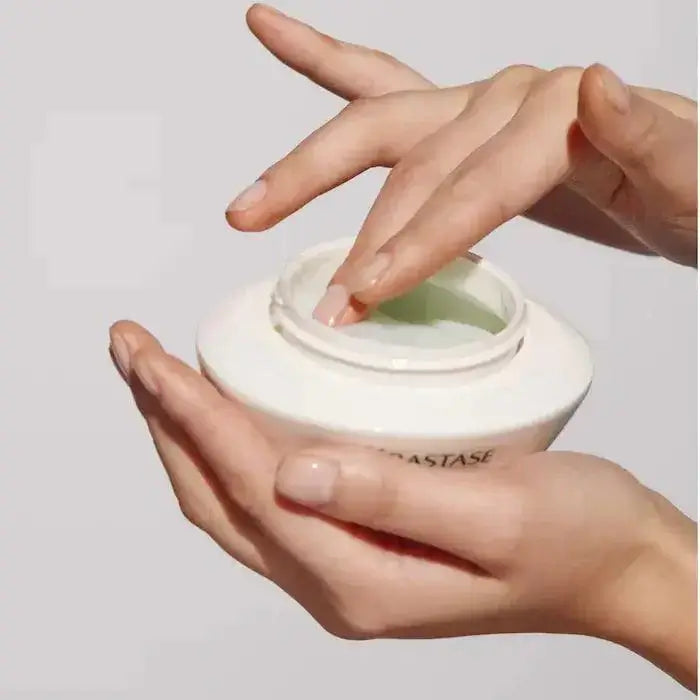 Person applying Kerastase Spécifique Masque Réhydratant hair mask, ideal for moisturizing dry and sensitive scalps.
