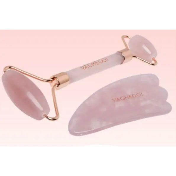 Rose quartz Gua Sha stone and roller set for facial massage and reducing stress, featuring gold accents on a light pink background.