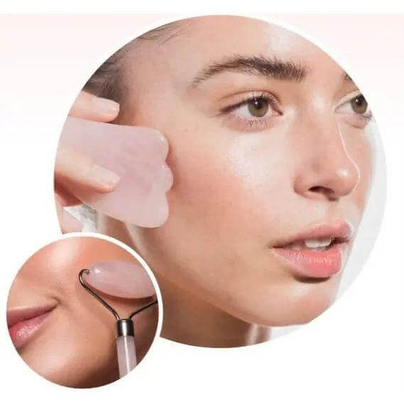 Woman using pink Gua Sha stone and rose quartz roller for facial massage to reduce wrinkles and improve skin appearance.