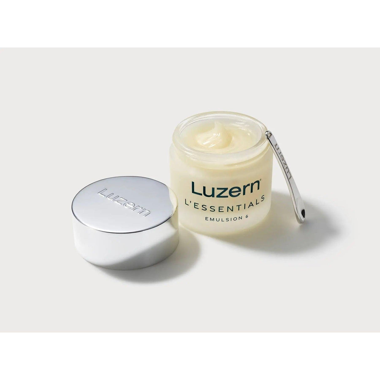 L'Essentials Emulsion 6 open jar with melting balm and lid, featuring a skincare product with 6 nutrient-dense oils for cleansing and hydration.