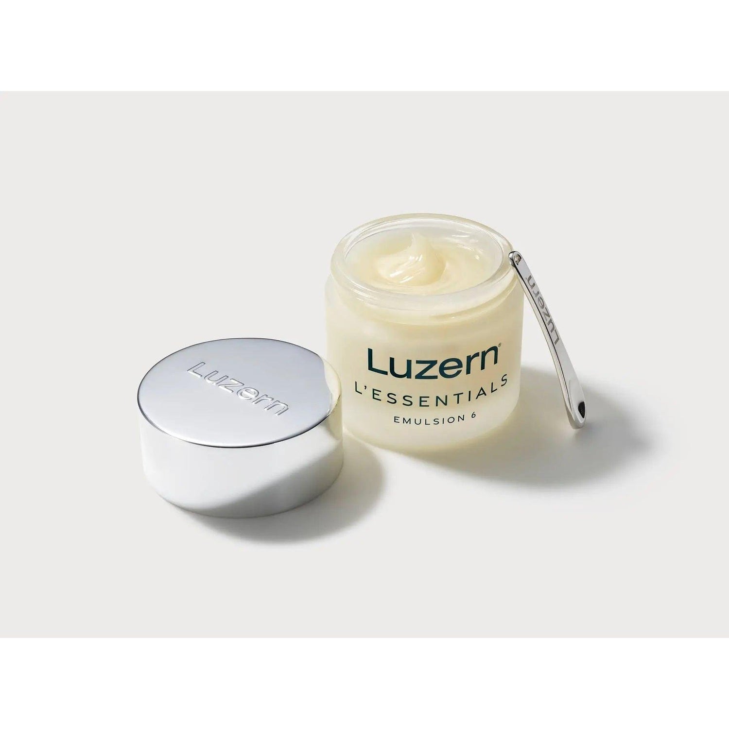L'Essentials Emulsion 6 open jar with melting balm and lid, featuring a skincare product with 6 nutrient-dense oils for cleansing and hydration.