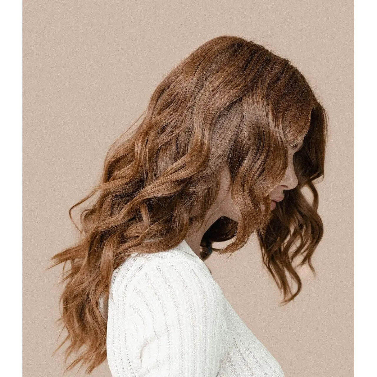 Woman with wavy hair styled with Kérastase L'Incroyable Blow Dry, showcasing frizz-free, flexible hold and shine on brown hair.