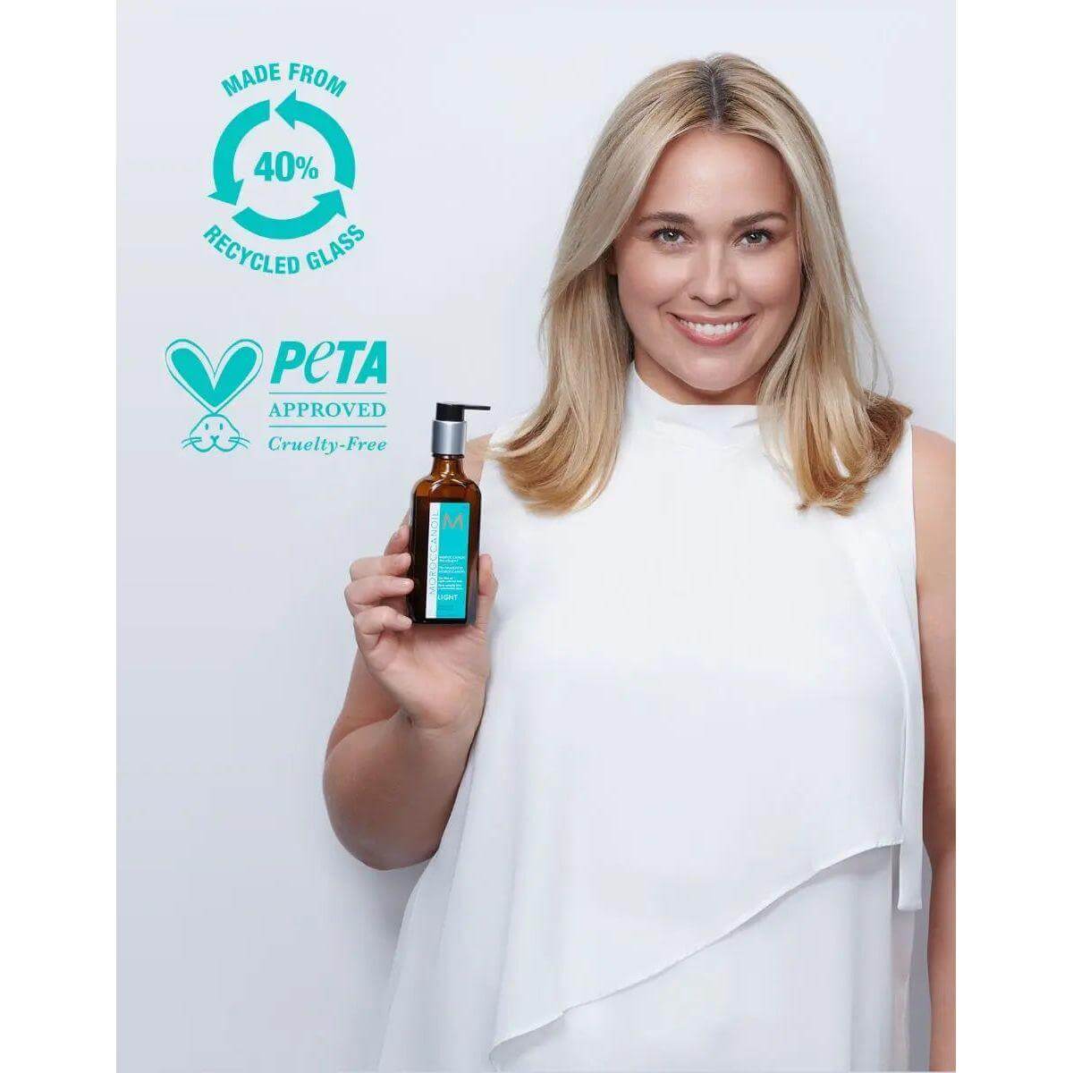 Woman holding Moroccanoil hair treatment bottle, highlighting PETA cruelty-free approval and 40% recycled glass packaging.
