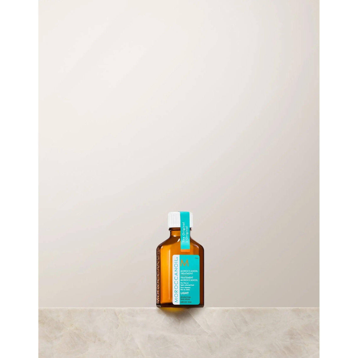 Moroccanoil Light Treatment bottle with argan oil for frizz control and shine, designed for fine hair, on a neutral background.