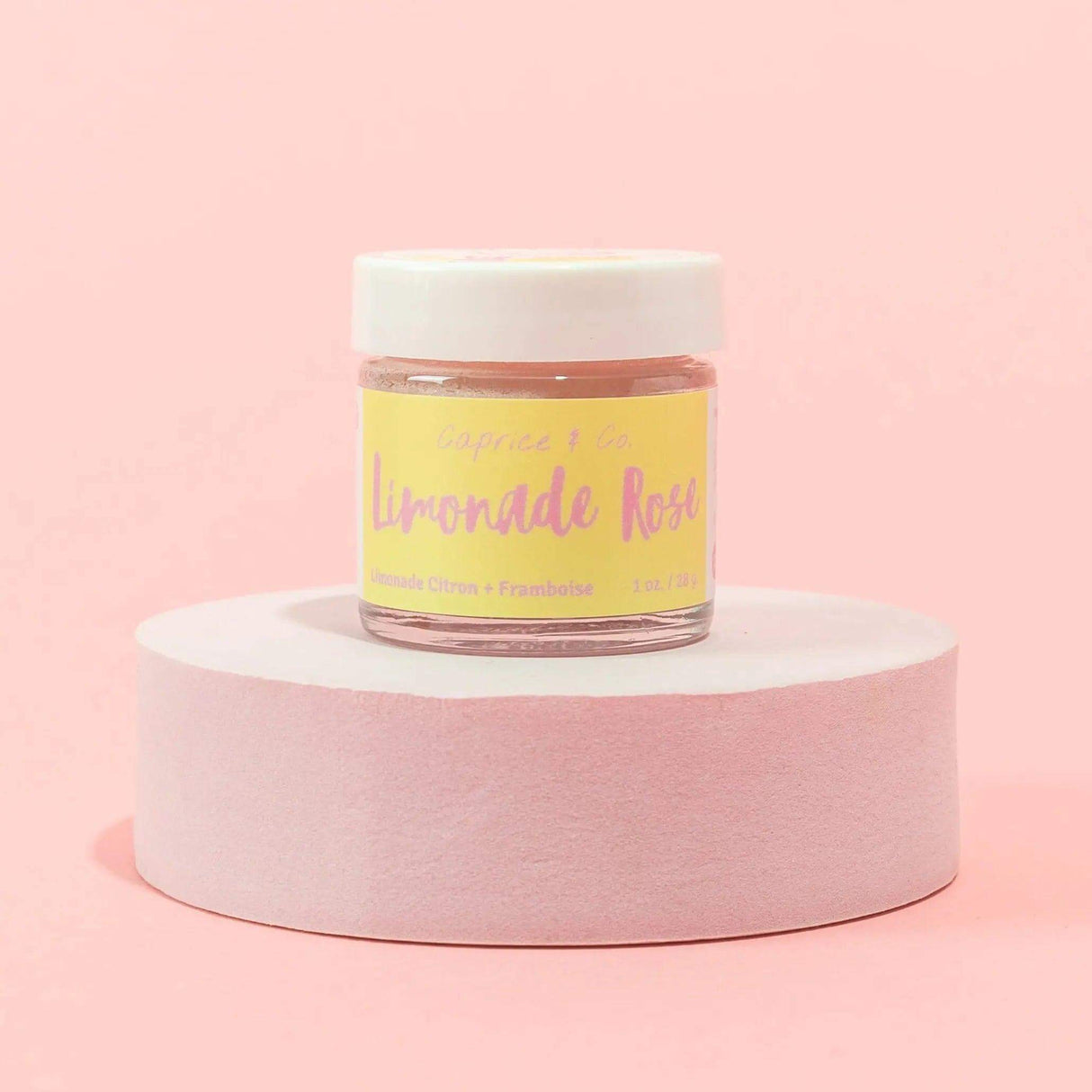 Limonade Rose lip scrub 1oz with lemonade and raspberry flavor, displayed on a pink background, ideal for exfoliating and hydrating lips.
