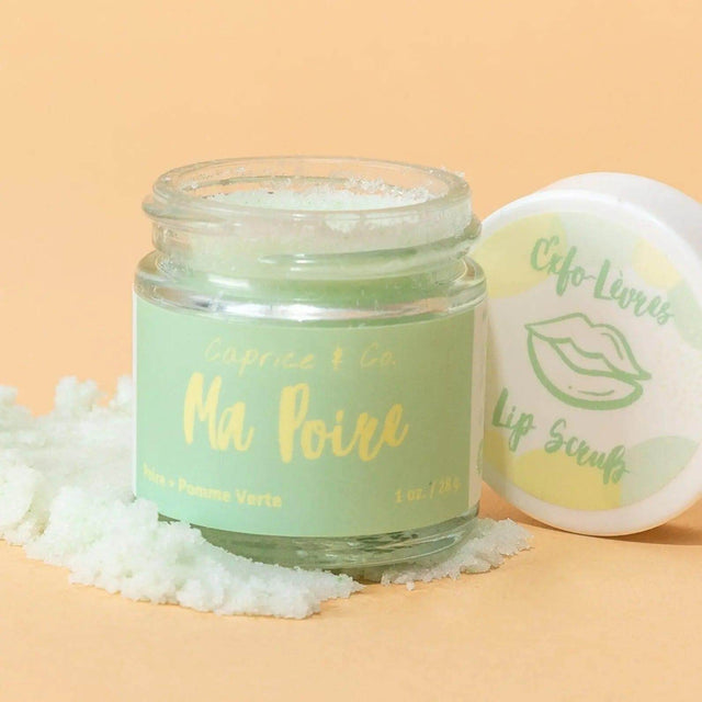 Caprice & Co. Ma Poire Lip Scrub jar with pear and green apple flavor on a peach background, exfoliating sugar around the jar.