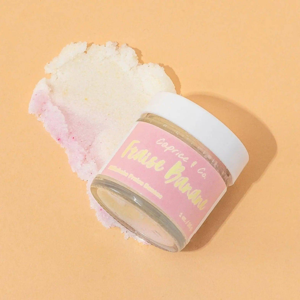Strawberry Banana Lip Scrub jar on a light background, showcasing the product's texture and premium packaging.