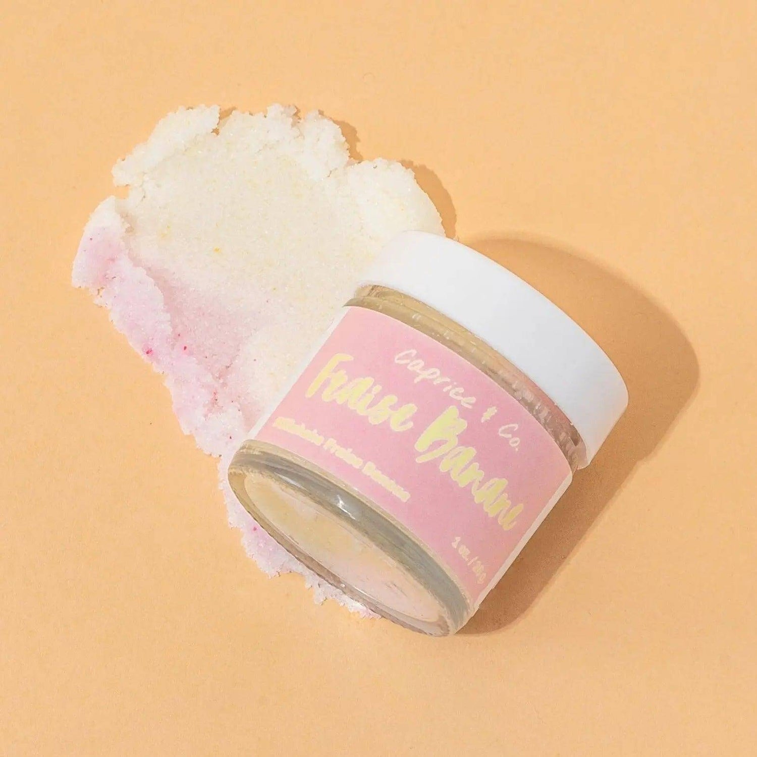 Strawberry Banana Lip Scrub jar on a light background, showcasing the product's texture and premium packaging.