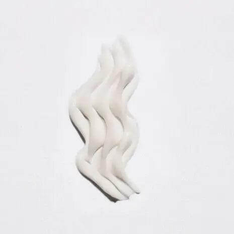 Creamy texture of Kérastase Masque Curl Idéal hair mask for frizz control and curl definition on a white background.