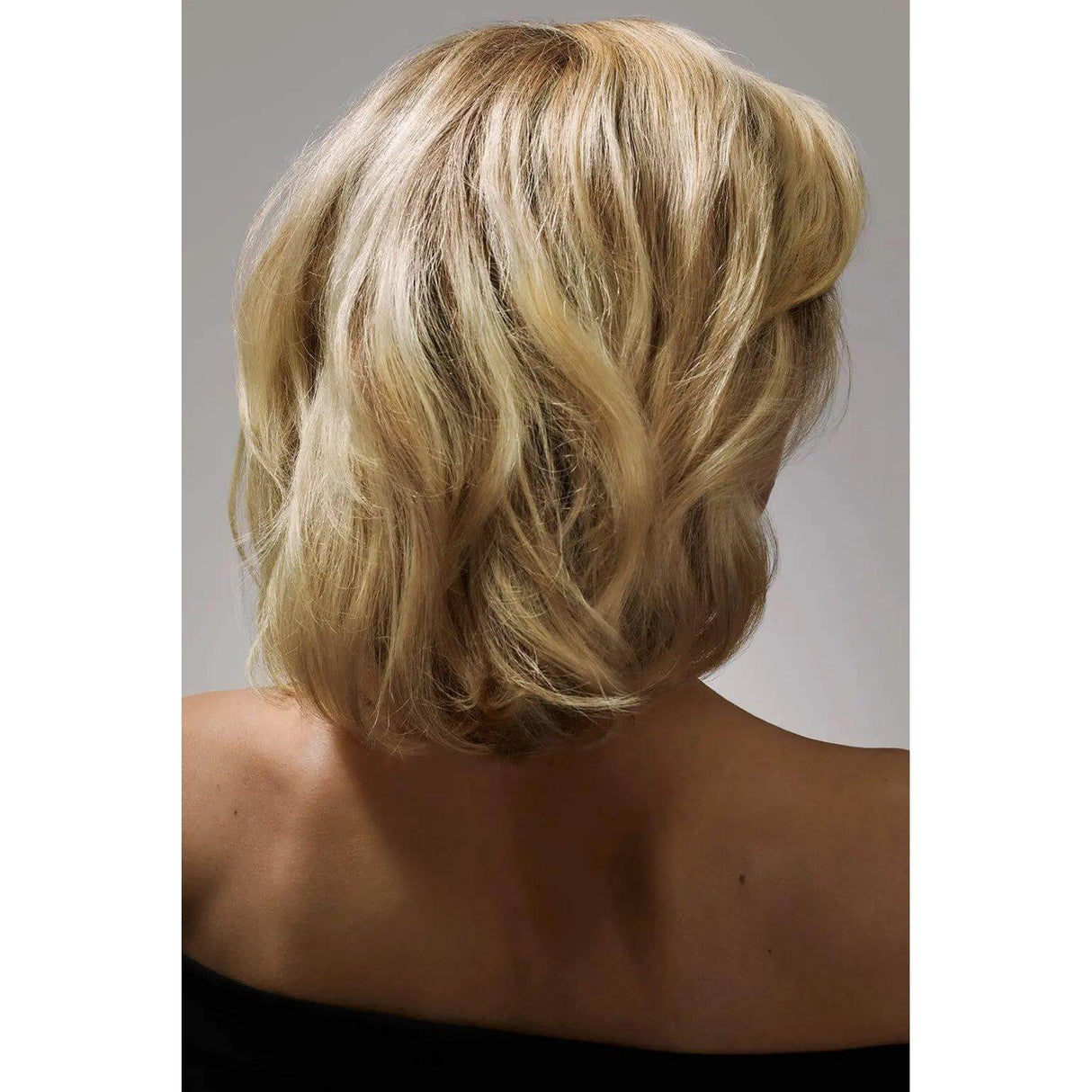 Back view of voluminous blonde hair styled with thickening spray for a fuller appearance