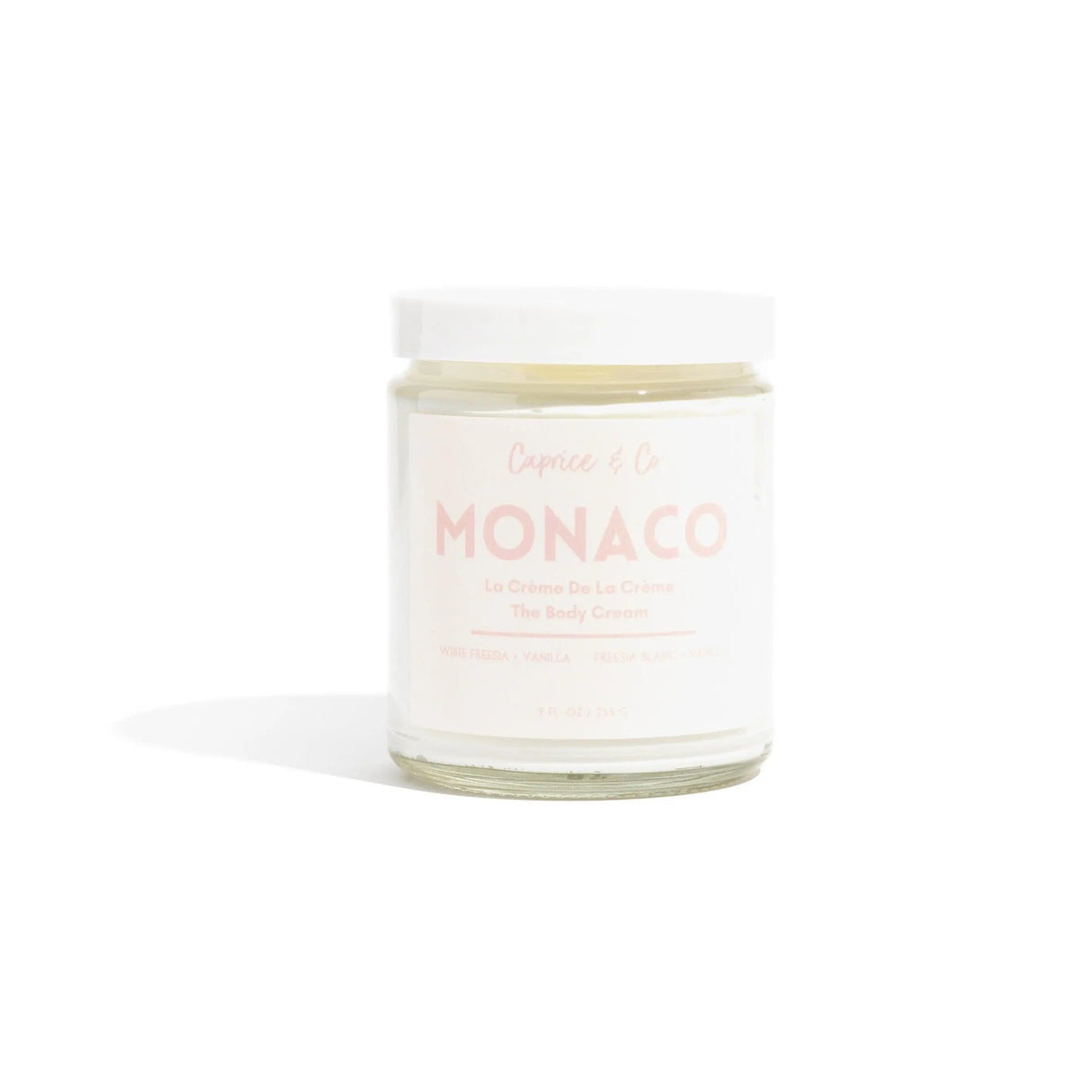 Monaco body cream in glass jar scented with white freesia and vanilla, made with coconut, jojoba oil, and shea butter, 9 fl oz.