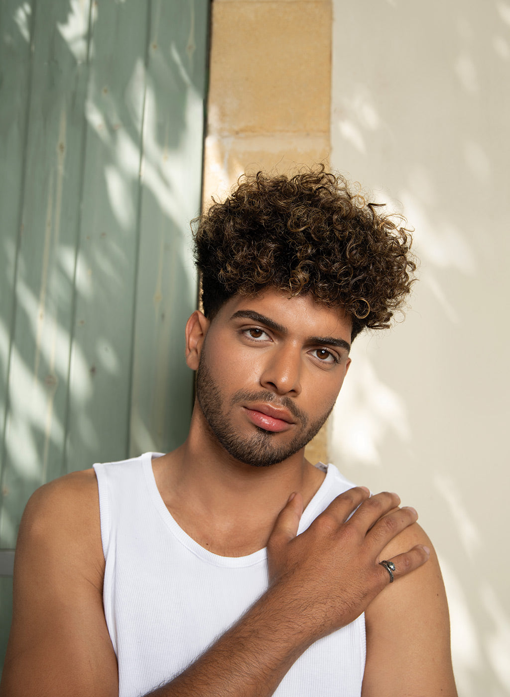 Man with curly hair styled using Neu Styling Fiber, offering texture and volume with a matte finish. Ideal for managing flyaways.