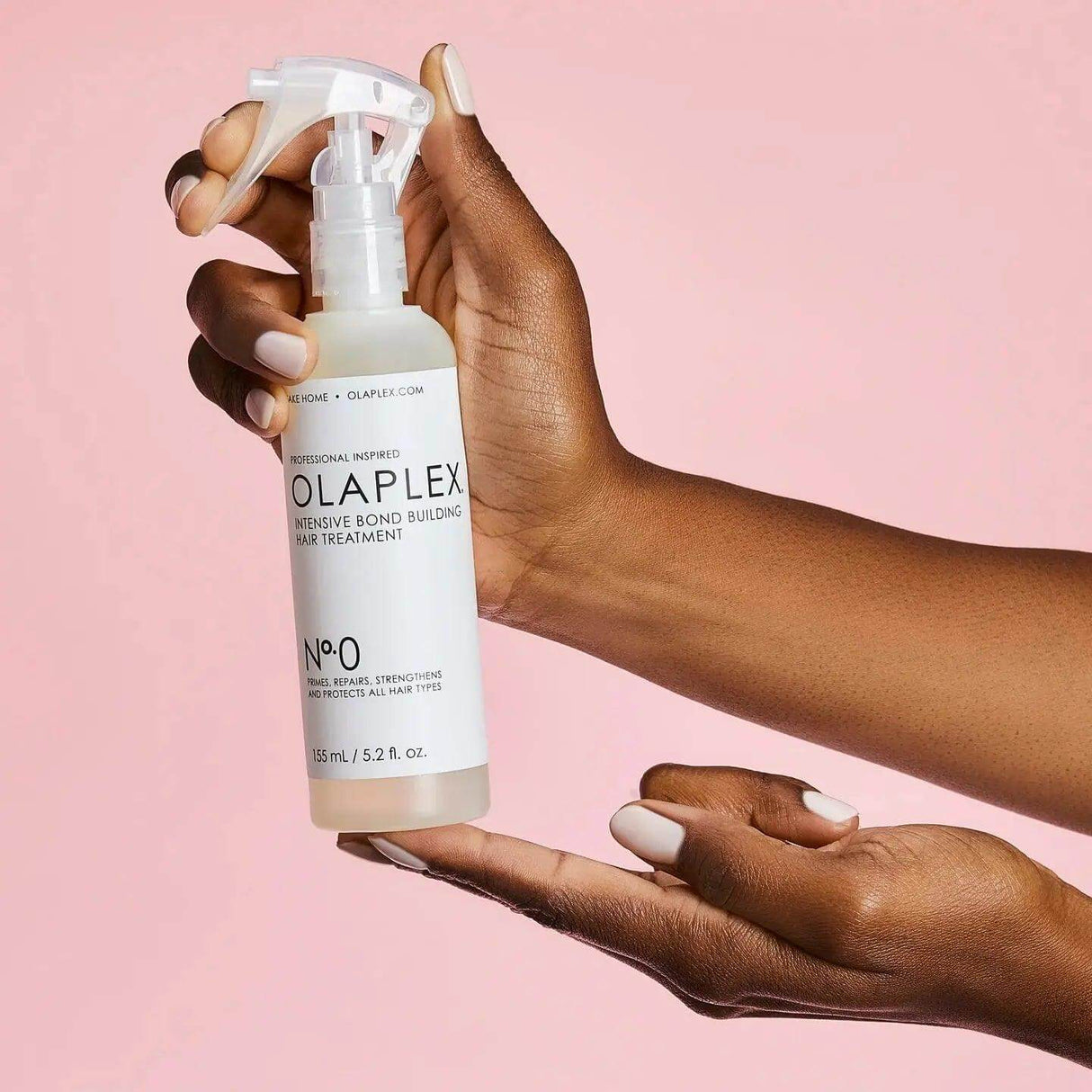 Olaplex Nº.0 Intensive Bond Building Treatment bottle held in hand, designed to repair and strengthen damaged, chemically-treated hair.