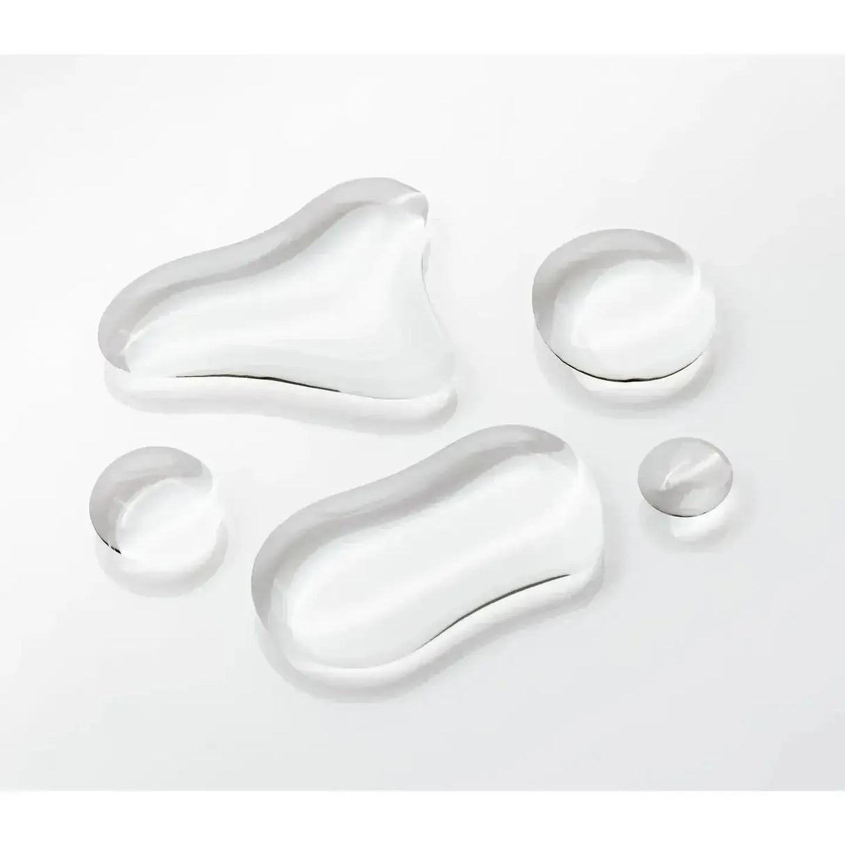 Close-up of clear liquid drops, representing the Olaplex Nº.0 Intensive Bond Building Treatment on a white background.