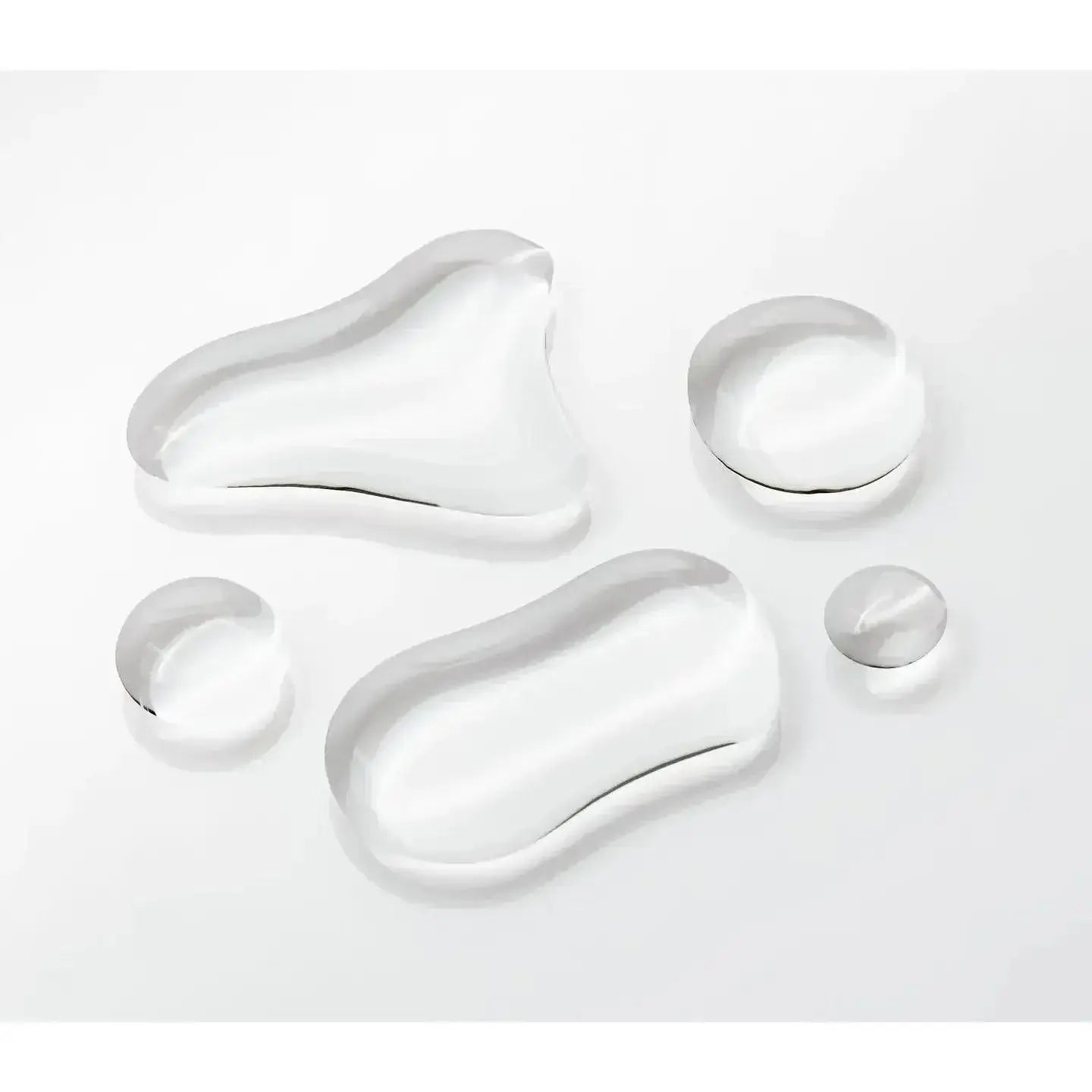 Close-up of clear liquid drops, representing the Olaplex Nº.0 Intensive Bond Building Treatment on a white background.