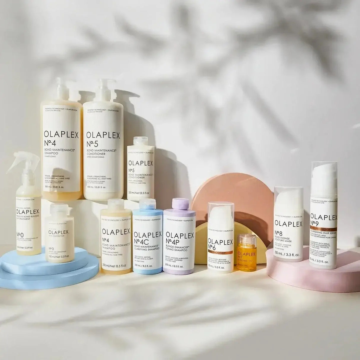 Various Olaplex hair care products, featuring Nº.5 Bond Maintenance Conditioner, displayed on decorative stands.
