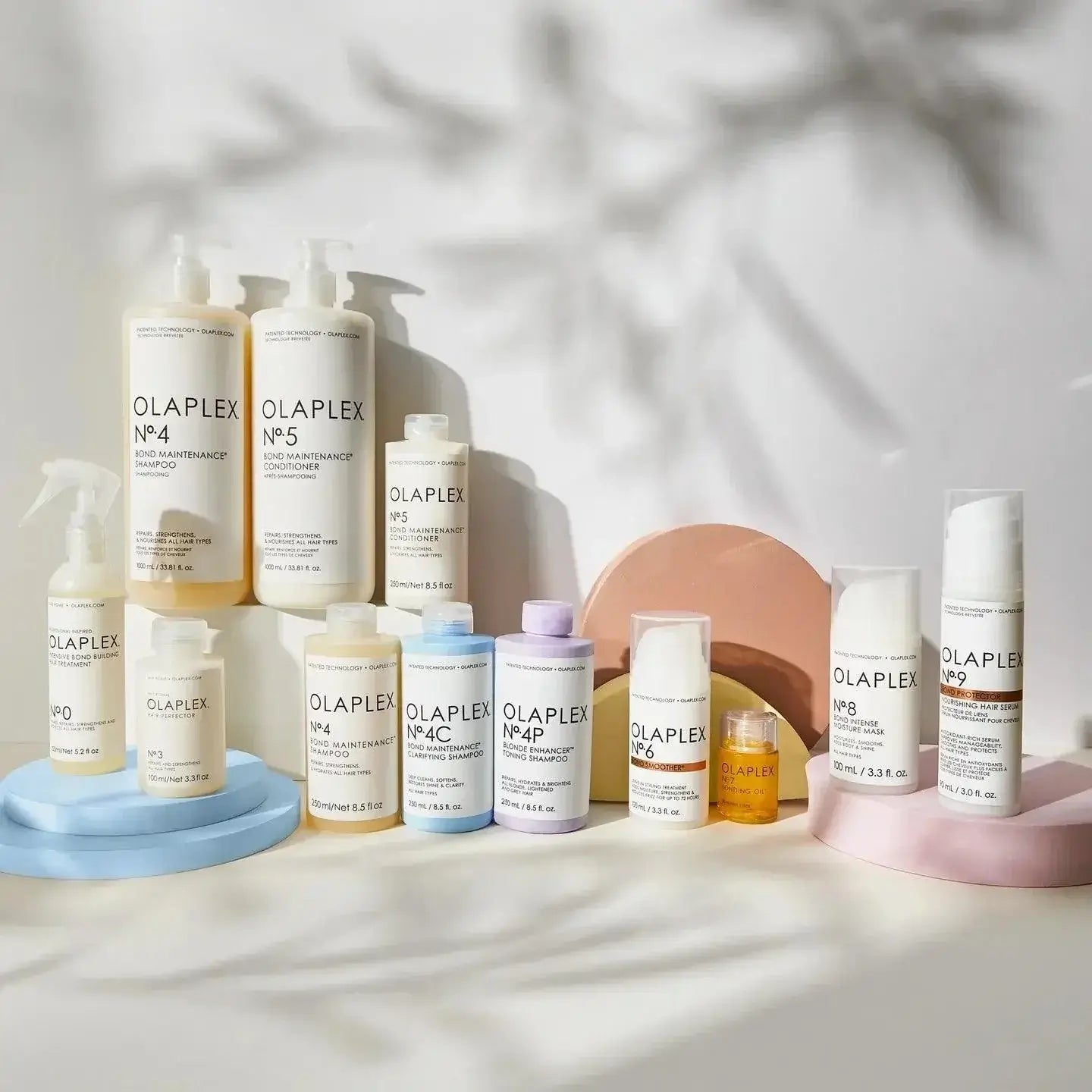 Various Olaplex hair care products, featuring Nº.5 Bond Maintenance Conditioner, displayed on decorative stands.