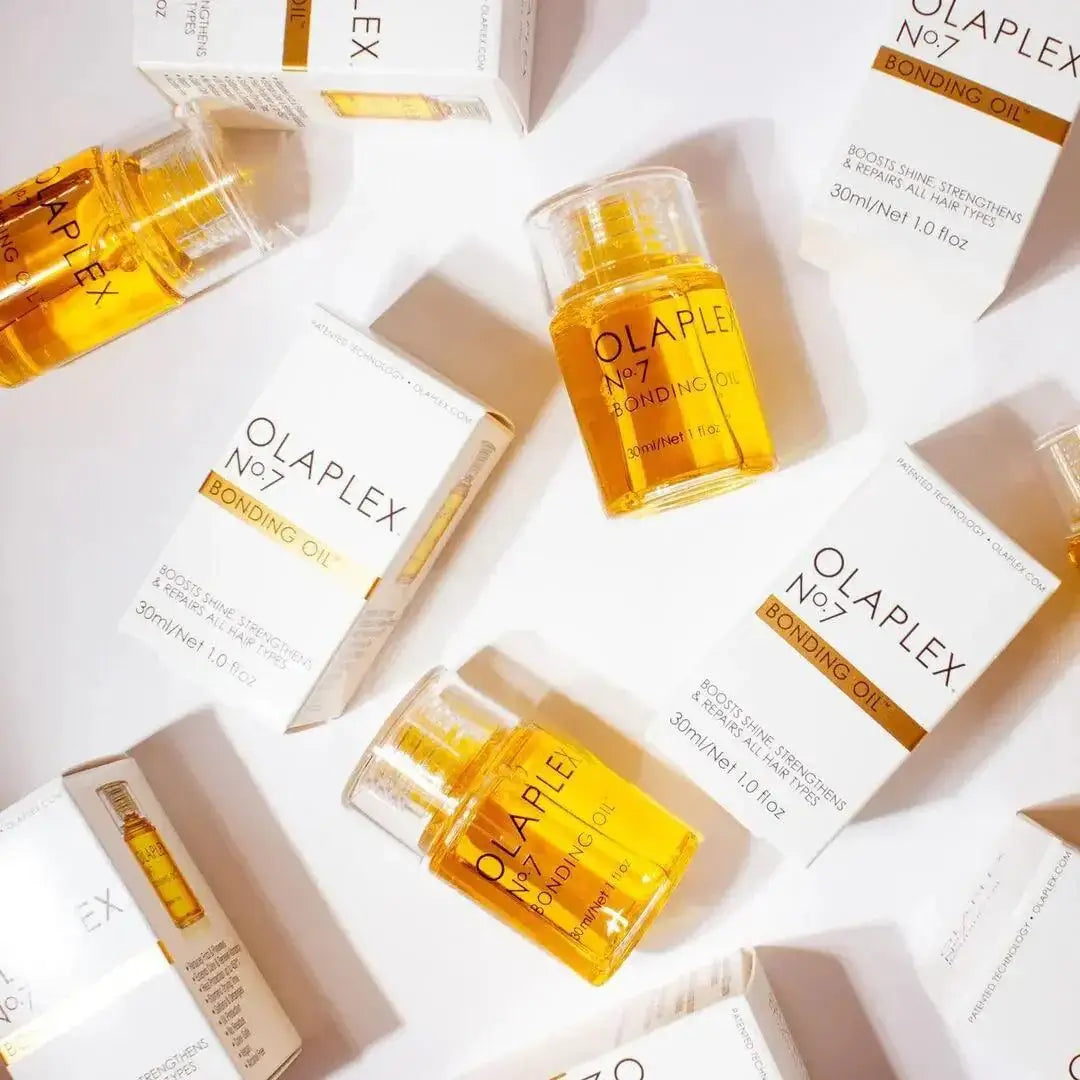Olaplex Nº.7 Bonding Oil bottles and packaging arranged on a white background for hair restoration and hydration.