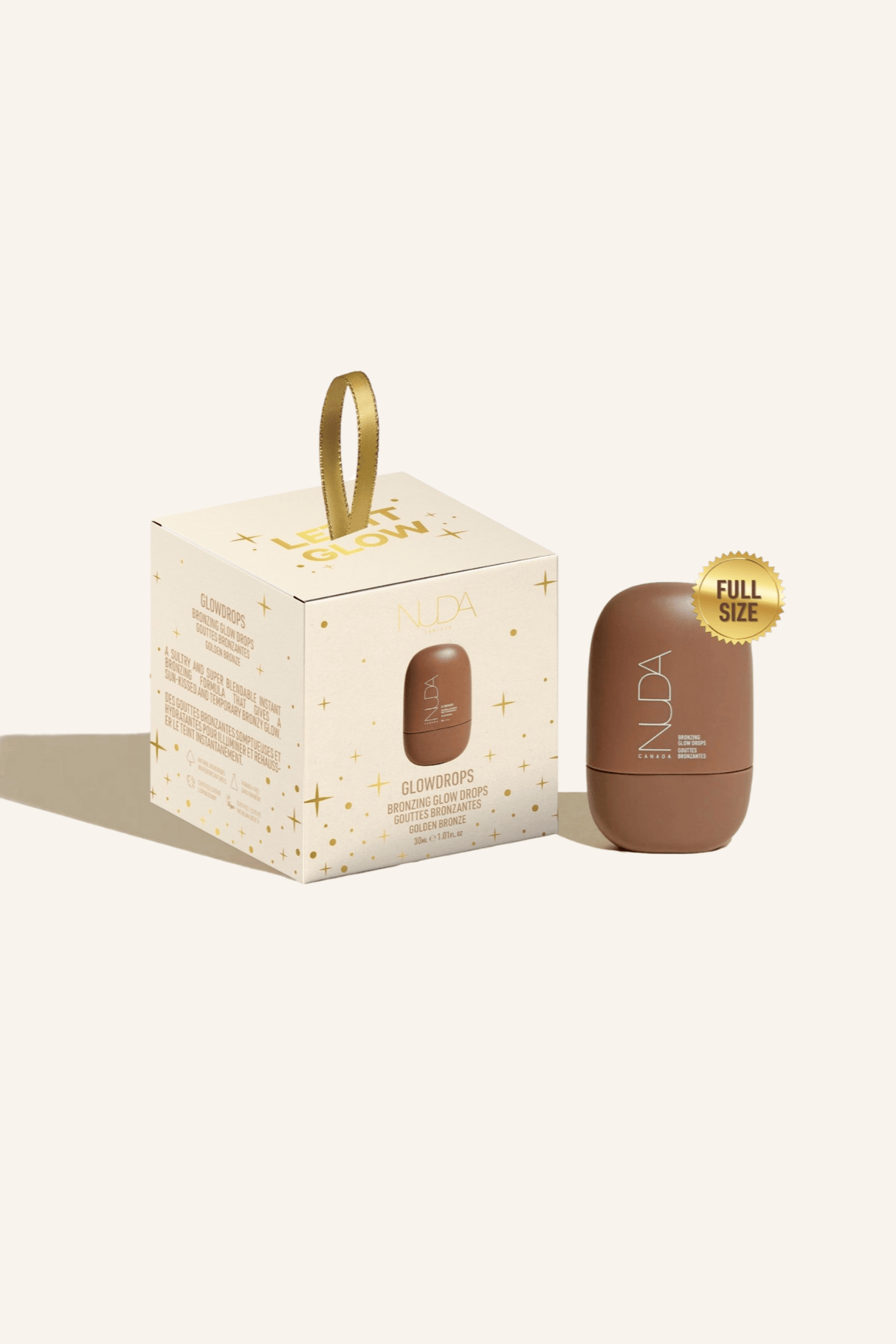 Nuda Let It Glow Ornament with Bronzing Glow Drops in elegant holiday packaging.