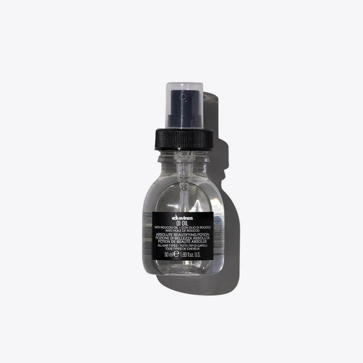 Oi Oil hair product for shine and frizz control in a transparent bottle against a white background.