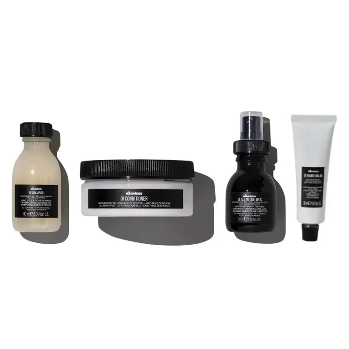 Davines Oi Travel Gift Set with Oi Shampoo, Conditioner, All-In-One Milk, and Hand Balm for hair care and skin hydration.