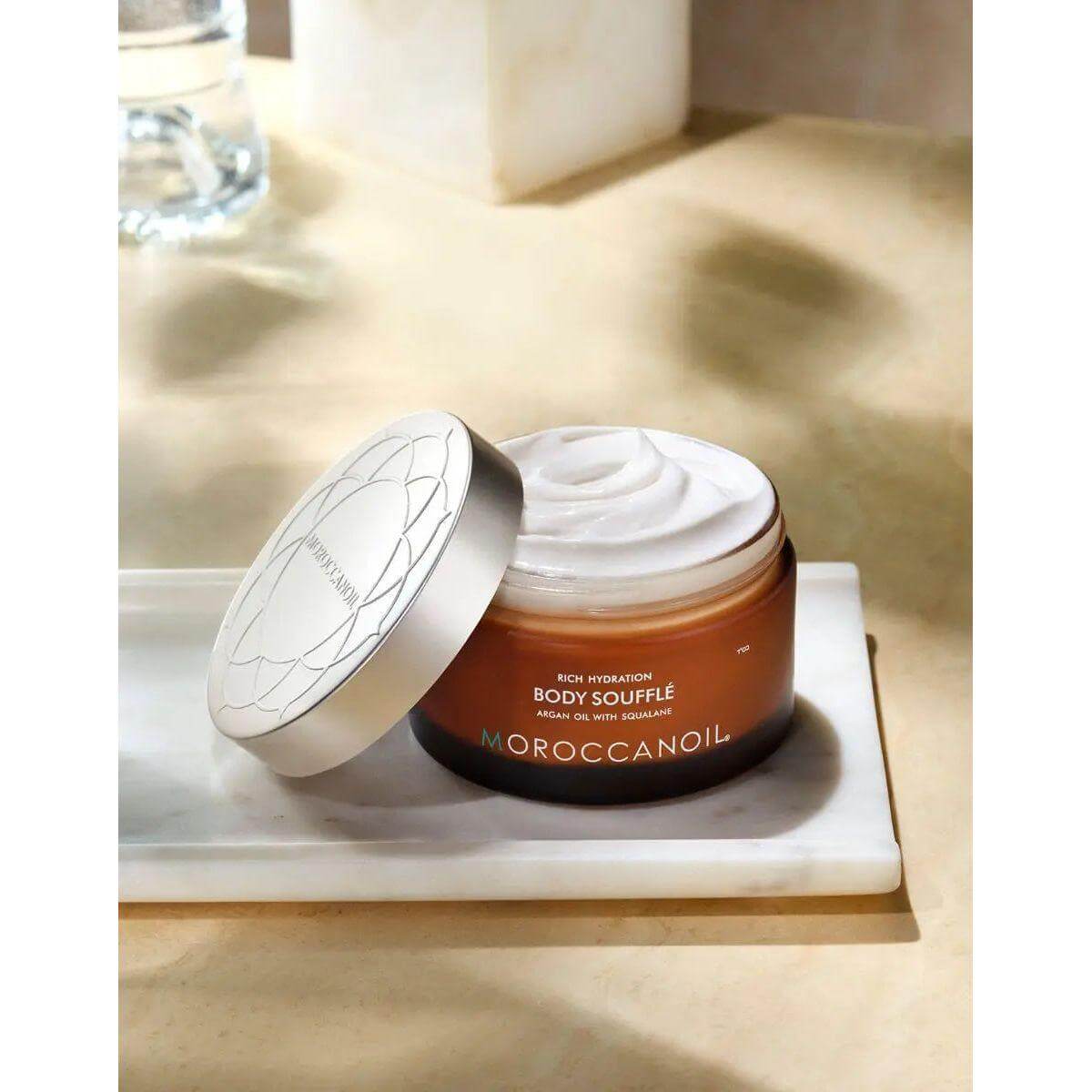 Jar of Original Body Soufflé moisturizer with lid open, showcasing smooth, whipped texture. Perfect for daily hydration with nourishing oils.